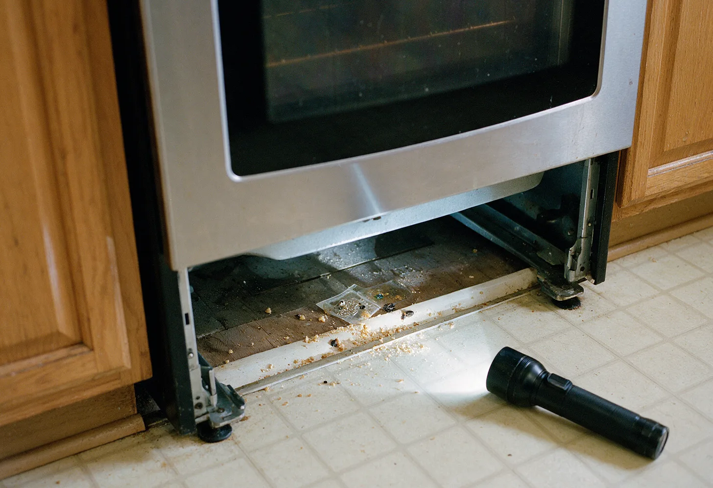 The floor gap behind a pulled-out stove with a monitor trap
